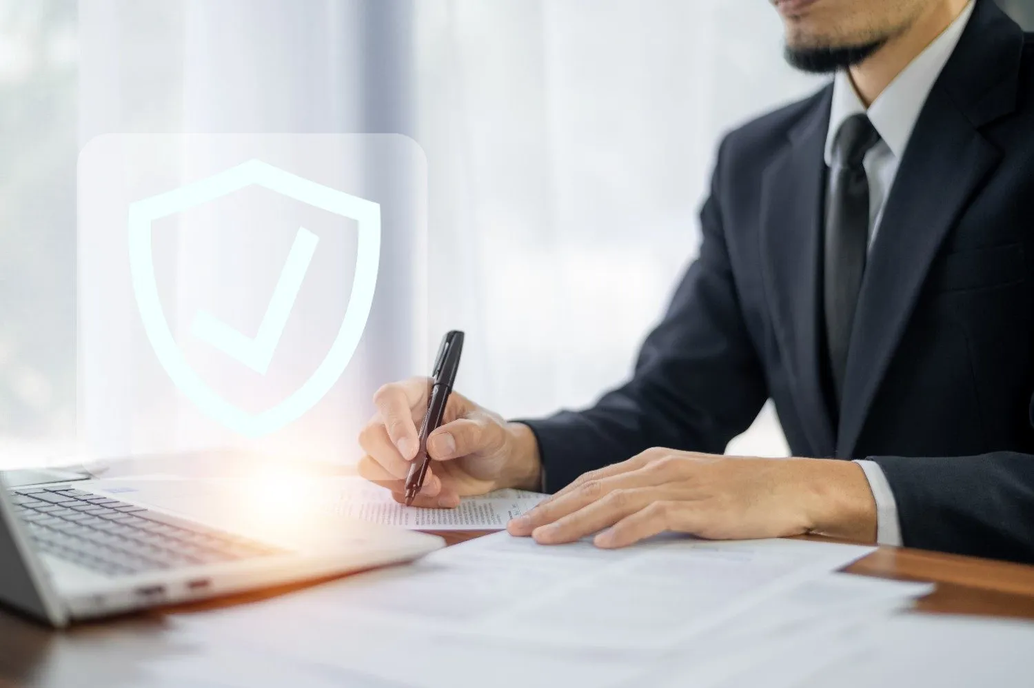 A business owner in a suit signing a document at a desk